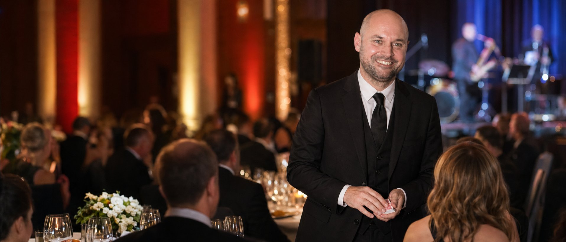 Sean Piper performing close-up card magic at a corporate gala event